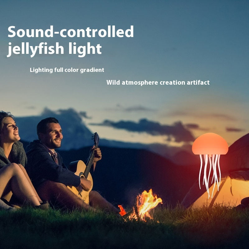 Couple sitting by a campfire with a sound-controlled jellyfish light in the foreground, set against a mountainous landscape.